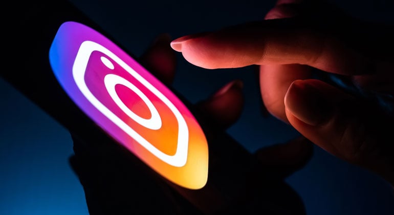 Hand selecting Instagram app icon