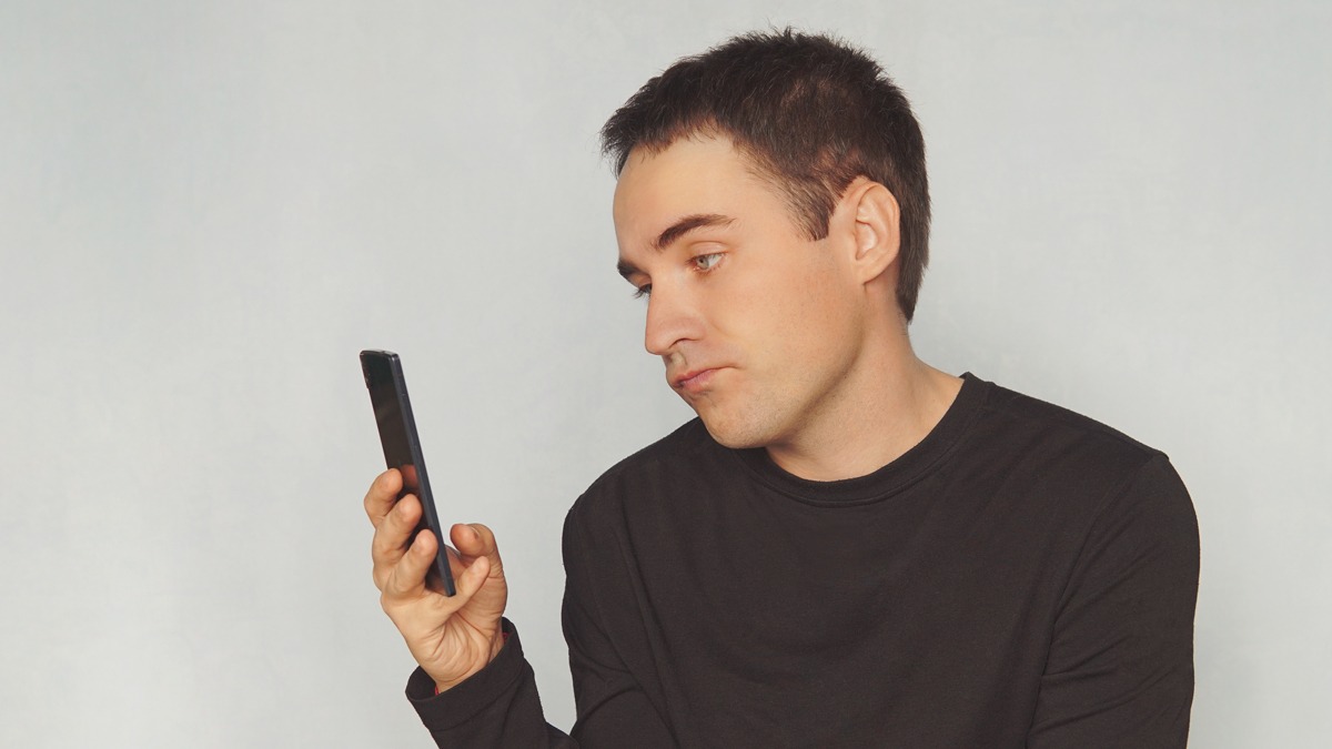 Bored man looking at phone